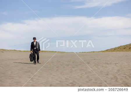 走在沙丘上的男性商人 108726649
