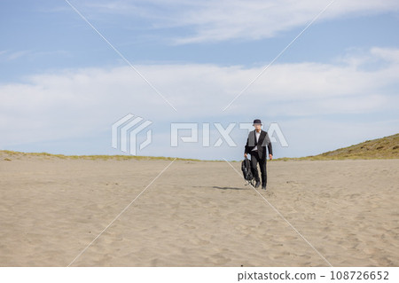 Mysterious man in a suit on the beach 108726652