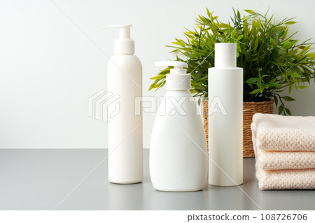 Set of blank cosmetic bottles and towels on gray background 108726706