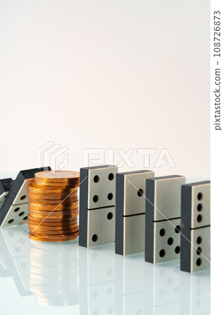Domino tiles in a row and coins close up. Financial crisis concept 108726873