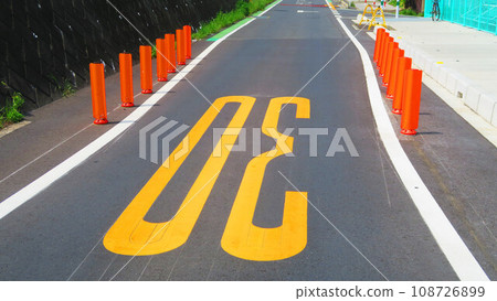 Scenery of an asphalt road with a sign that the width has been reduced 108726899