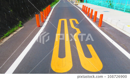 Scenery of an asphalt road with a sign that the width has been reduced 108726900