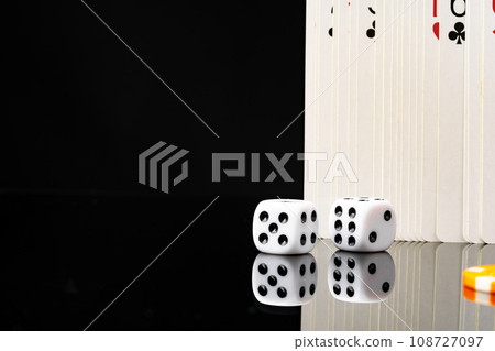 Playing cards and dice cubes on black background Playing cards and dice cubes on black background 108727097