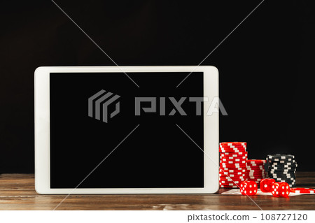 Poker chips and smartphone on wooden table 108727120