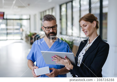 Pharmaceutical sales representative talking with doctor in medical building. Ambitious female sales representative presenting new medication. Woman business leader. 108728288