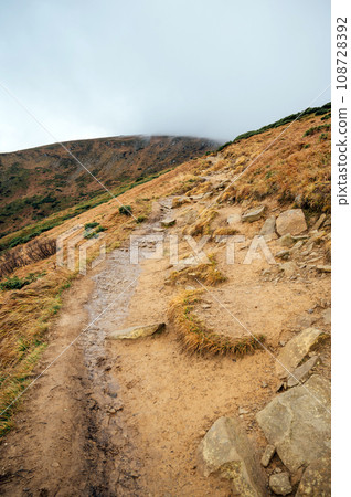 Golden autumn in the Carpathians. Mining arrays combined with trees with yellow leaves. Beautiful clouds and sun Golden autumn in the Carpathians. Mining arrays combined with trees with yellow leaves. Beautiful clouds and sun 108728392