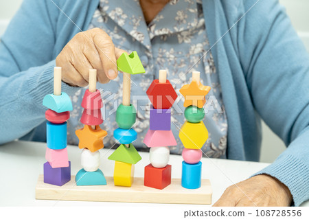Alzheimer disease AD, Asian elderly woman patient suffering from dementia learn practical motor skills rehabilitation. Alzheimer disease AD, Asian elderly woman patient suffering from dementia learn practical motor skills rehabilitation. 108728556