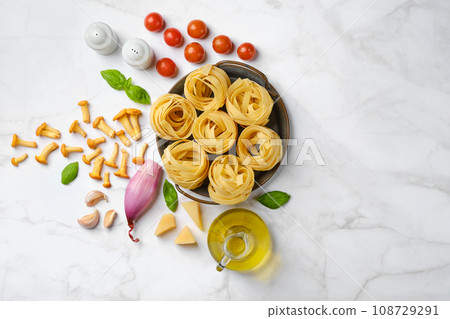 Raw ingredients for mushroom pasta scattered on stone background Raw ingredients for mushroom pasta scattered on stone background 108729291