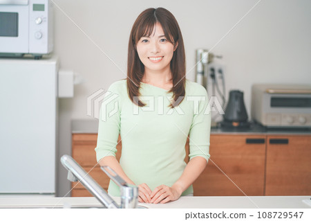 Young woman standing in the kitchen Young woman standing in the kitchen 108729547