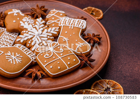 Beautiful Christmas gingerbread cookies of different colors on a ceramic plate Beautiful Christmas gingerbread cookies of different colors on a ceramic plate 108730583