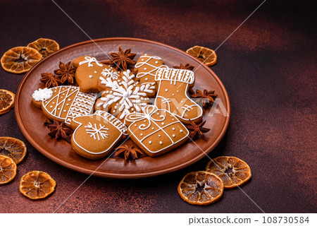 Beautiful Christmas gingerbread cookies of different colors on a ceramic plate Beautiful Christmas gingerbread cookies of different colors on a ceramic plate 108730584
