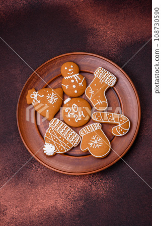 Beautiful Christmas gingerbread cookies of different colors on a ceramic plate 108730590