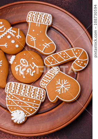 Beautiful Christmas gingerbread cookies of different colors on a ceramic plate Beautiful Christmas gingerbread cookies of different colors on a ceramic plate 108730594