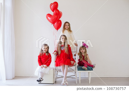 four children with red balloons in a bright holiday room four children with red balloons in a bright holiday room 108730757