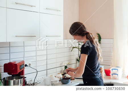 a woman cooks delicious food pastries in the kitchen 108730830