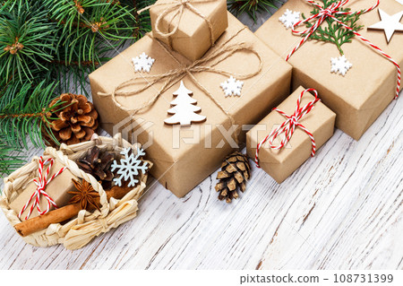 Christmas gift boxes and fir tree branch with basket on wooden table Christmas gift boxes and fir tree branch with basket on wooden table 108731399