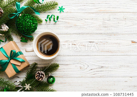 Delicious fresh festive morning coffee in a ceramic cup with little wrapped gifts, ornament and xmas toy. Cup of coffee and new year toys 108731445