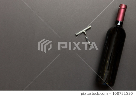 One Bottle of red wine with corkscrew on colored table. Flat lay, top view wth copy space One Bottle of red wine with corkscrew on colored table. Flat lay, top view wth copy space 108731550