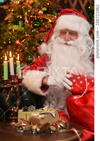 Santa Claus in a traditional costume sits with gifts Santa Claus in a traditional costume sits with gifts 108731962