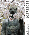 The face of a Buddha statue surrounded by cherry blossoms 108732055