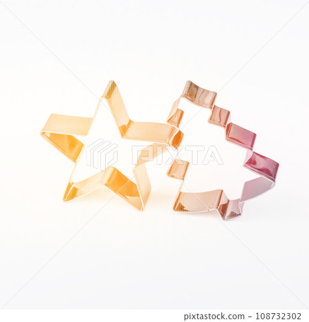 Colored cookie cutters in the shape of a Christmas fir tree and star on white background. 108732302