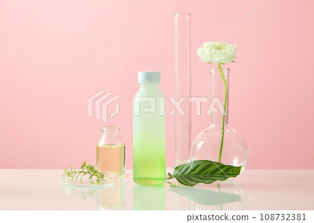 Laboratory concept with an empty label bottle arranged with a petri dish and other glassware. Research and development cosmetics concept. Pink background Laboratory concept with an empty label bottle arranged with a petri dish and other glassware. Research and development cosmetics concept. Pink background 108732381