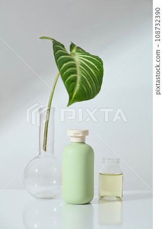 Cosmetic bottle without label displayed with a flat-bottom florence flask and a jar filled with essential oil. Research production of cosmetics. Mockup design Cosmetic bottle without label displayed with a flat-bottom florence flask and a jar filled with essential oil. Research production of cosmetics. Mockup design 108732390