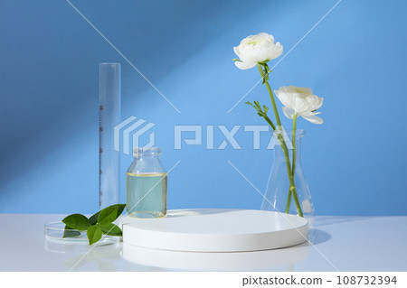 Over blue background, an empty podium and some laboratory glassware are arranged. Minimal pedestal for beauty, cosmetic product presentation 108732394