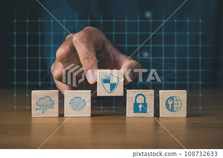 Businessman holding wooden block of cyber security icons. Digital information technology and cyber security concept. Businessman holding wooden block of cyber security icons. Digital information technology and cyber security concept. 108732633