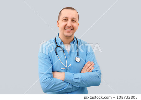 Portrait of a happy male doctor looking at the camera on a light background. 108732805