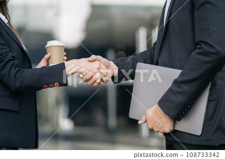 Businessmen shake hands after agreeing to start a new project successfully. 108733342