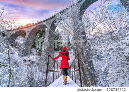 Tourist visiting Landwasser Viaduct world heritage in Swiss Alps snow winter scenery, Switzerland. 108734832