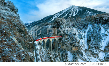 Landscape of Train passing through famous mountain in Filisur, Switzerland. Landwasser Viaduct world heritage with train express in Swiss Alps snow winter scenery. 108734833