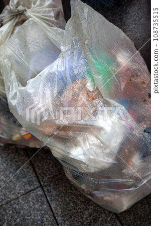 Trash can on a sidewalk in the rain Trash can on a sidewalk in the rain 108735515