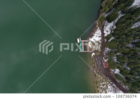 Aerial view of a lake boat dock. Flying above a vessel pier 108736074