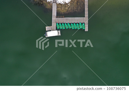 Aerial view of a lake boat dock. Flying above a vessel pier Aerial view of a lake boat dock. Flying above a vessel pier 108736075