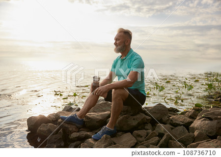 Old mature sportsman enjoying beautiful wild nature after morning jog 108736710