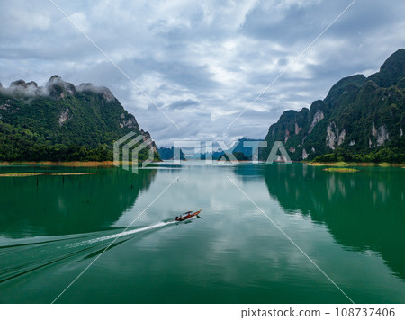 Aerial drone view of tourist boat on the lake of tropical Mountain peak , Khao Sok National Park, Thailand 108737406
