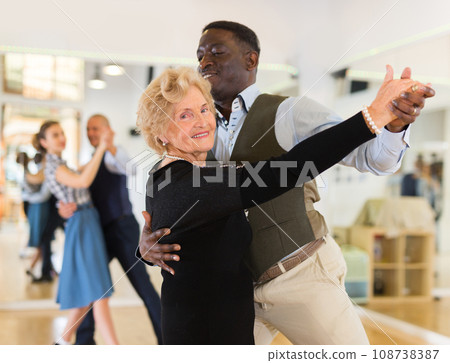Man and senior woman dancing waltz in studio 108738387