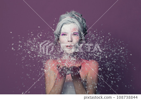 Joyful model woman with creative makeup and white snow on colorful purple background Joyful model woman with creative makeup and white snow on colorful purple background 108738844