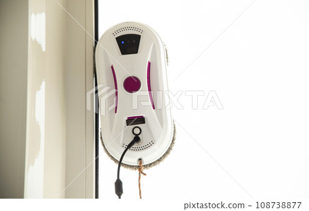 A modern device, a vacuum robot window cleaner, cleans glass from dirt and streaks with safety from falls from a height. Copy space for text, technology A modern device, a vacuum robot window cleaner, cleans glass from dirt and streaks with safety from falls from a height. Copy space for text, technology 108738877