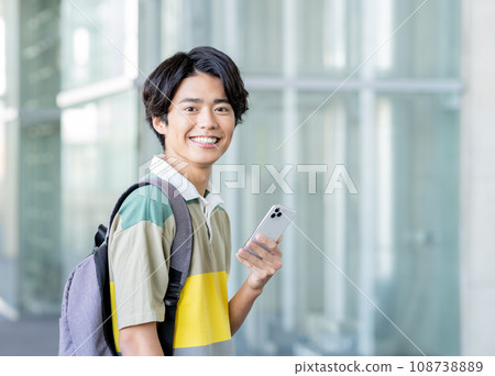 Young college boy looking at smartphone Young college boy looking at smartphone 108738889
