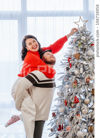 couple having fun decorating christmas tree 108738958