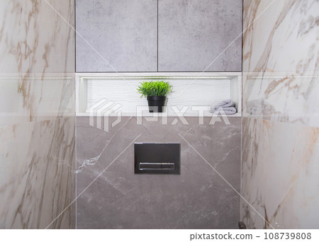 The interior in a modern toilet, a closet and a niche with a shelf and a diode tape in the back wall of the toilet room. The interior in a modern toilet, a closet and a niche with a shelf and a diode tape in the back wall of the toilet room. 108739808