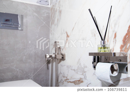 Aroma diffuser for a pleasant smell in the toilet against the backdrop of a hygienic shower. Air freshener in the toilet. Copy space for text Aroma diffuser for a pleasant smell in the toilet against the backdrop of a hygienic shower. Air freshener in the toilet. Copy space for text 108739811