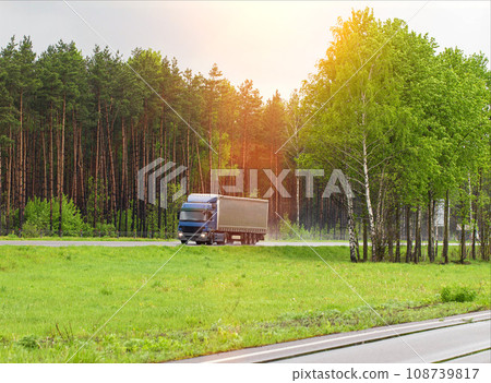 A truck with a semi-trailer transports cargo in summer in cloudy rainy weather on a wet road in the rain. Skidding on the road. Import substitution, export and import of goods. Trucking business, A truck with a semi-trailer transports cargo in summer in cloudy rainy weather on a wet road in the rain. Skidding on the road. Import substitution, export and import of goods. Trucking business, 108739817