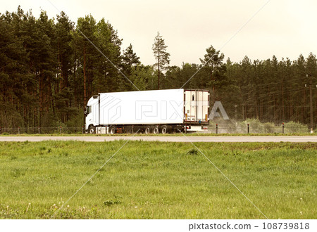 A truck with a semi-trailer transports cargo in summer in cloudy rainy weather on a wet road in the rain. Skidding on the road. Import substitution, export and import of goods. Trucking business, A truck with a semi-trailer transports cargo in summer in cloudy rainy weather on a wet road in the rain. Skidding on the road. Import substitution, export and import of goods. Trucking business, 108739818