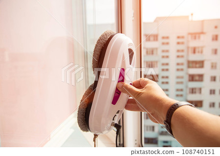 Connecting a vacuum window cleaner robot to a balcony frame, close-up Connecting a vacuum window cleaner robot to a balcony frame, close-up 108740151