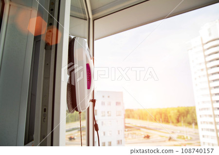 Automatic vacuum robot window cleaner washes glass in the apartment, balcony frame, Copy space for text 108740157