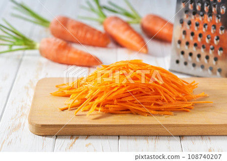 grated  organic carrots on a cutting board,  selective focus. 108740207